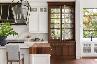 white kitchen with brown wood hutch