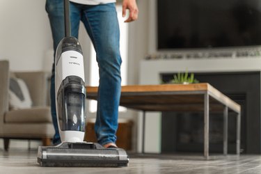 person using white and gray wet dry vacuum