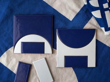 overhead view of blue and white textiles with blue and white handpainted tiles in geometric pattern