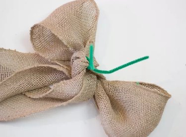 A ribbon bow with a green pipe cleaner