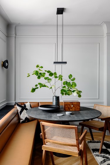dining room with gray walls, brown seating, and black table