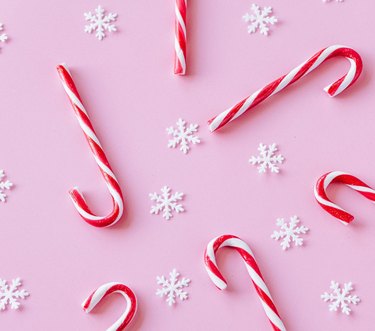 candy canes on pink background with white snowflakes