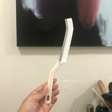 person holding slim angled brush