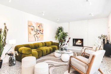 living room space with green couch and white furniture