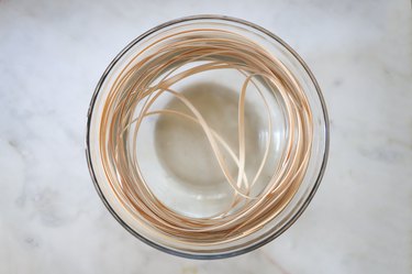 Soaking flat reed in bowl of warm water