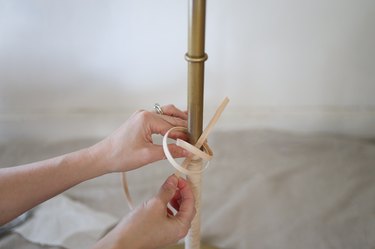 Tying reed into knot around floor lamp