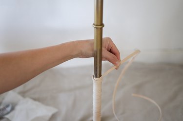 Tying reed into knot around floor lamp