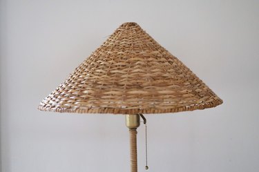 Conical rattan shade placed on top of floor lamp