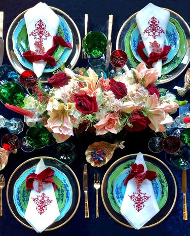 tablescape with large floral centerpiece and teal and green plates