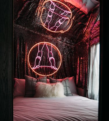renovated caravan with large cowboy neon reflected into mirrored ceiling