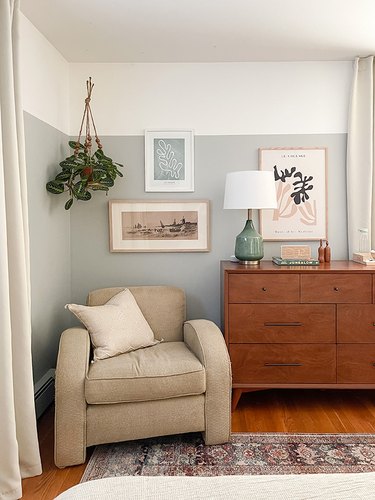 Bedroom corner with gray and white walls, a hanging plant, Boho, and Mid-Century accents.