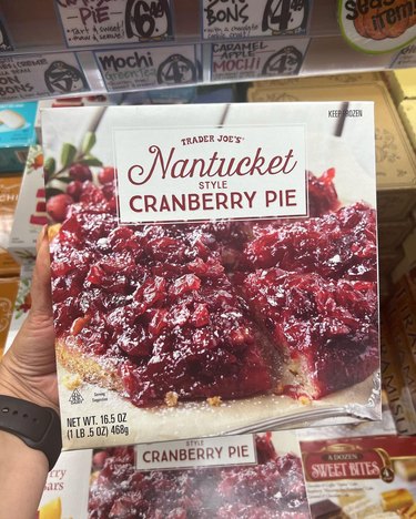A hand holding Nantucket-Style Cranberry Pie from Trader Joe's.