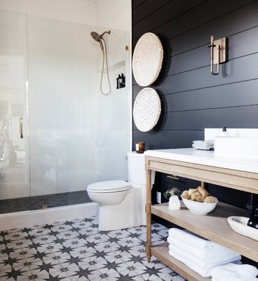 Industrial bathroom with black walls and patterned floors