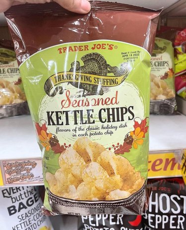 A hand holding Thanksgiving Stuffing Seasoned Kettle Chips from Trader Joe's.