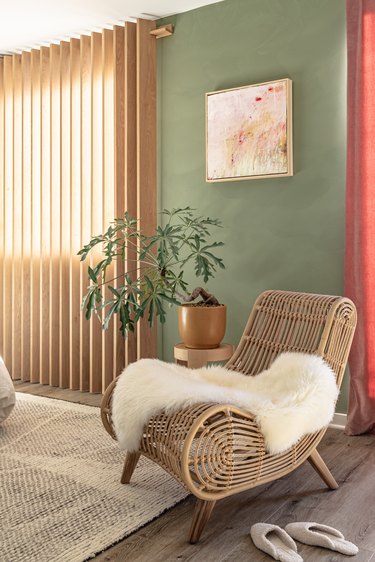 calm boho bedroom with rattan lounge chair, sheepskin and unusual plant