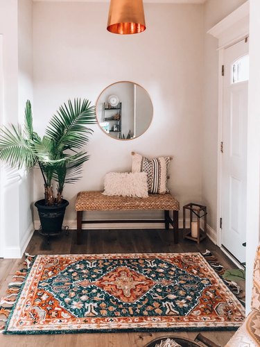 seagrass bench and vintage rug in entryway