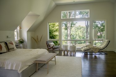 bedroom area with large windows and seating area