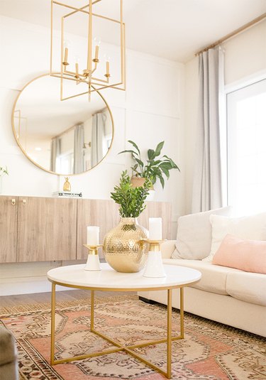 white living room with brass chandelier and coffee table