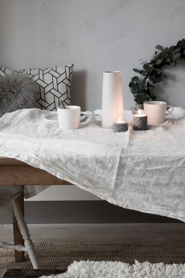 Wintery dining room with dining table with tea light candles and linen tablecloth