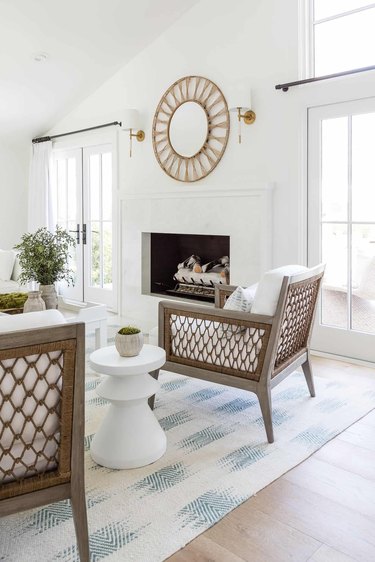 transitional white living room with round mirror