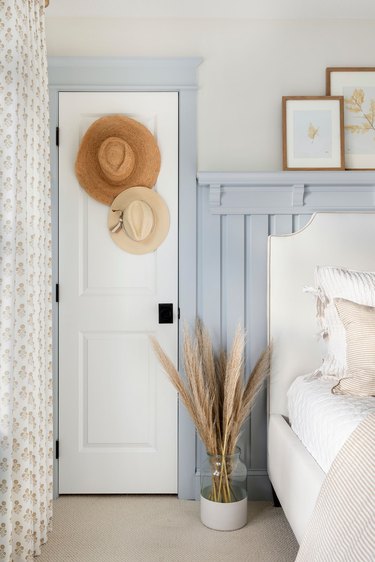 blue and white vintage bedroom with hanging hats