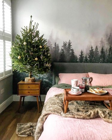 Wintery bedroom with coral and green linen bedding, faux fur throw, and Christmas tree