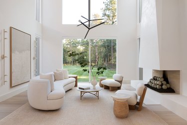 all white living room with high ceilings and a pair of modern chandeliers