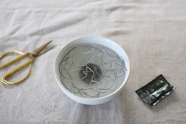Chicken wire and floral frog in bowl full of water