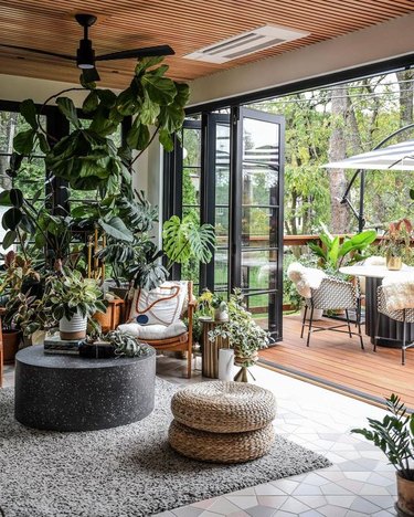 plant filled room open to outdoor patio