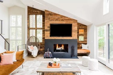 Modern living room with a fireplace, wood paneling and large area rug
