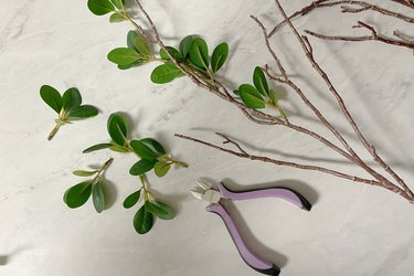 Small clusters of faux leaves clipped off faux branch stems