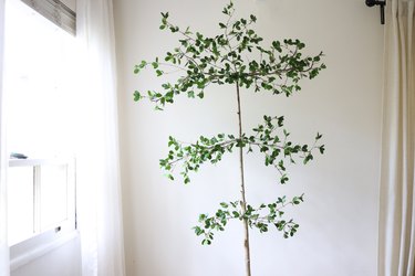 Three tiered faux tree with green leaves hot glued to it