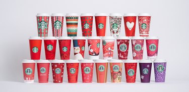 stack of 25 starbucks holiday cups from the last 25 years