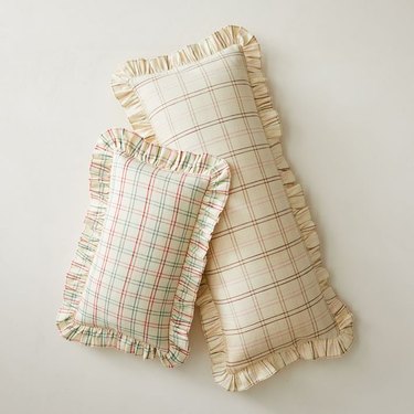 two ivory pillows with plaid stripes in reds and green