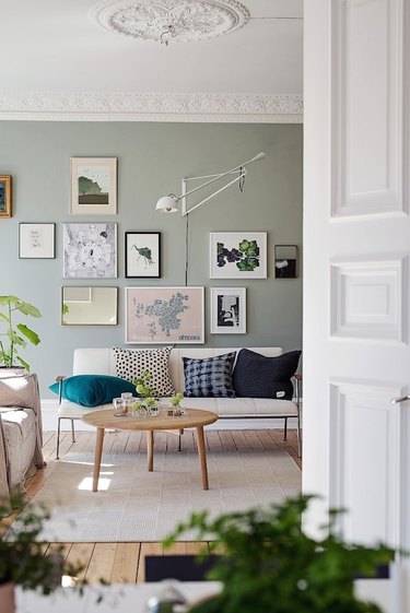living room with sage green walls and gallery wall