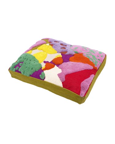 A rectangular dog red featuring tufted, textured random shapes in red, light purple, yellow, green, and pink.