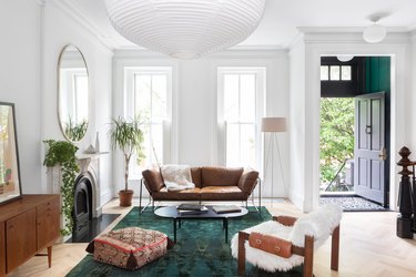 green area rug surrounded by crisp white walls and a green entryway