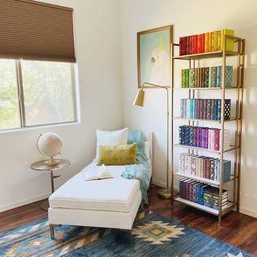 Home study with colorful books and a white chaise lounge