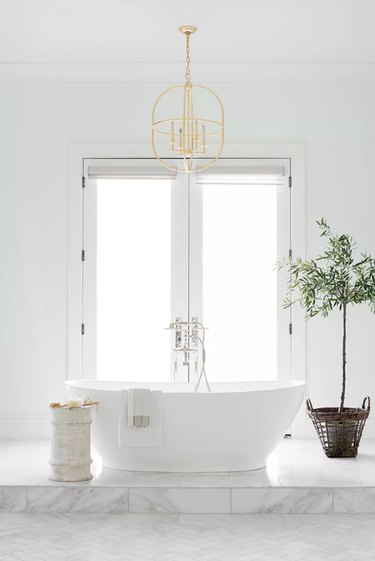 White claw tub with gold fixture above it