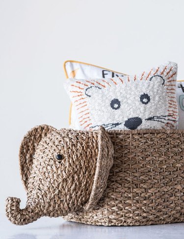 woven elephant basket with animal-printed pillows inside
