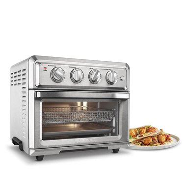 A stainless steel convection oven next to a plate of food