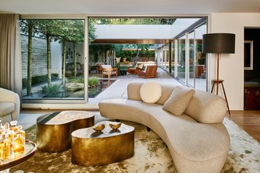 Living room with large glass door white couch and gold coffee tables