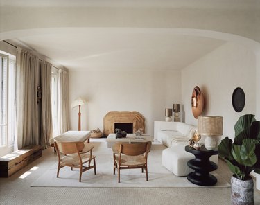 White living room with wooden chairs and fireplace