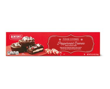 A long red box with "Benton's" in the top left corner, above three fudge covered peppermint cremes. They are small cookies coated with chocolate with a cream-filled center, topped with crushed peppermint candy.