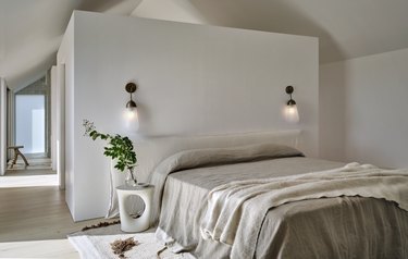 White bedroom with grey bed and white bedside table