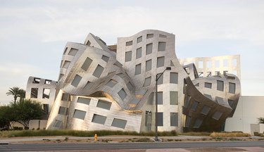 Shiny metal building with a melty shape and many windows