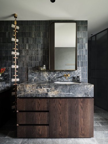 charcoal gray tile and marble countertop with chocolate brown wood vanity cabinety