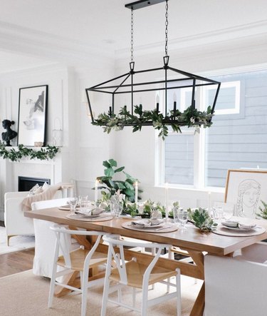 Dining room with holiday decor on chandelier, table, chairs.