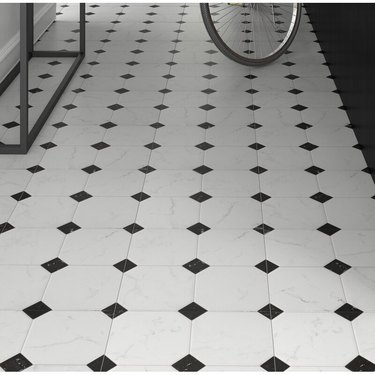 A black and white ceramic tile floor with a diamond pattern