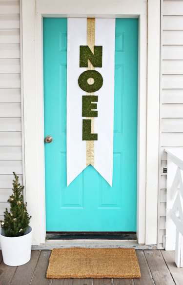 Turquoise front door with Christmas banner.